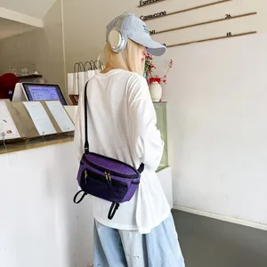 Μοντέλο που αναδεικνύει μια μοβ καρό λειτουργική τσάντα μέσης πεζοπορίας σε περιβάλλον καφετέριας