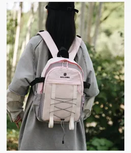 Mochila de senderismo al aire libre con contraste de colores rosa y gris usada por modelo