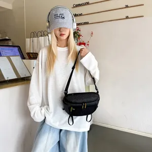 Μοντέλο που φοράει μαύρη καρό τσάντα techwear σε ένα κομψό περιβάλλον μοντέρνας καφετέριας
