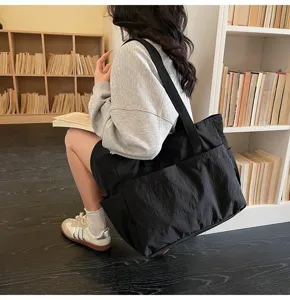 Minimalistische große schwarze Umhängetasche für Studenten in einer Bibliotheksumgebung