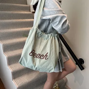 Bolso tote informal verde claro con cordón y estampado 'Beach' en un entorno de vida