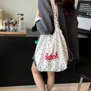 Bolso tote informal blanco con lunares y bordado Beach rojo en ambiente lifestyle.
