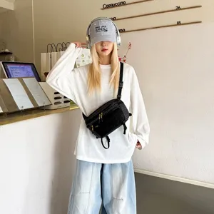 Μαύρη αδιάβροχη τσάντα στήθους techwear φορεμένη από μοντέλο σε κομψό περιβάλλον