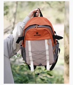 Primer plano de una mochila ligera de senderismo en naranja y gris con diseño color-block.