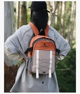 Vista posterior de persona con mochila ligera de senderismo naranja y gris en la naturaleza