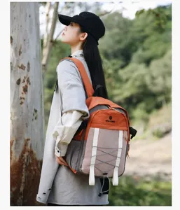 Mochila de senderismo al aire libre con diseño de bloques naranja usada por modelo