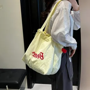 Detalle de bolso tote amarillo pálido de gran capacidad con bordado rojo Beach moderno