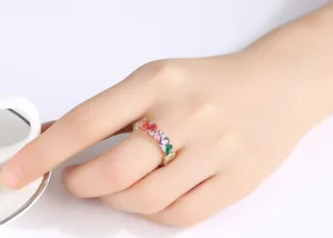 Detailopname van een prachtige regenboog edelsteen ring in roségoud aan de hand van model.