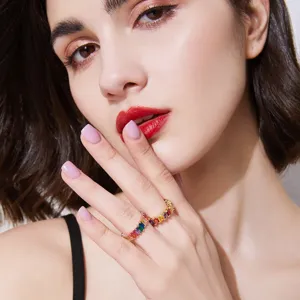Elegante anillo eternity de circonita arcoíris presentado en la mano de una modelo femenina