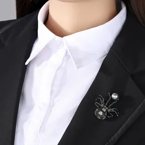 Elegante Spinnenbrosche mit schwarzen Zirkonia und grauer Perle an einem schwarzen Revers