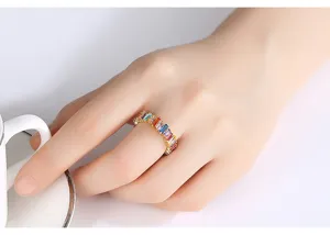 Gedetailleerde weergave van een elegante regenboog zirkonia ring om de vinger van een vrouw