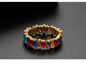 Detailopname van een vergulde ring met kleurrijke rechthoekige baguette zirkonia steentjes.