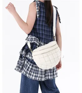 Back view of model wearing a stylish white quilted puffer crossbody chest bag