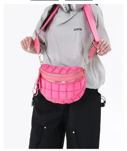 Model wearing a vibrant pink quilted bubble crossbody bag with adjustable wide strap.