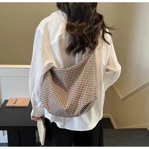 A detailed back view of a person wearing a brown checkered nylon canvas tote bag