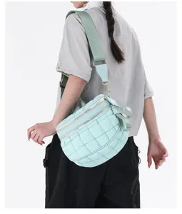 Mint green quilted puffer chest bag worn by a model in a stylish lifestyle setting.