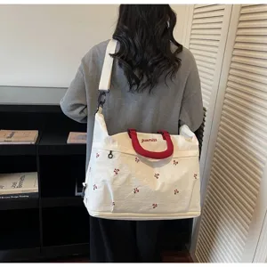 Large white canvas travel bag with red bow embroidery and adjustable shoulder strap