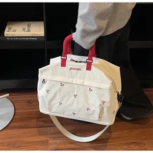 Close-up detail of fashionable large white travel bag with elegant red embroidery patterns