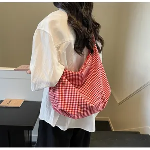 Red and white checkered nylon tote bag shown on a model for a casual, lightweight look.