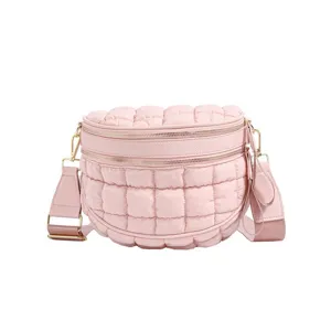 Stylish pink quilted puffer crossbody bag featuring a double zipper and wide adjustable strap