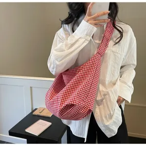 Stylish red and white checkered nylon tote bag worn by a model in a lifestyle setting
