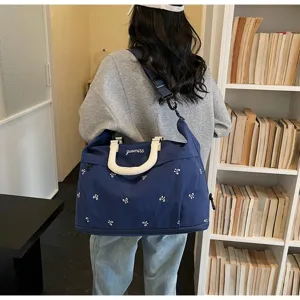 Large capacity blue floral travel bag shown on shoulder in a stylish lifestyle setting
