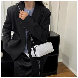 Detailaufnahme einer weißen Umhängetasche mit schwarzem Seilgurt an einem Model