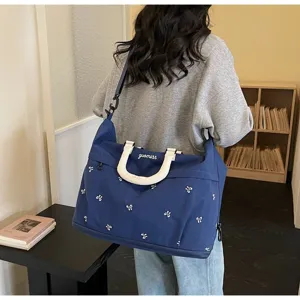Stylish blue large capacity travel bag with white bow embroidery and adjustable strap