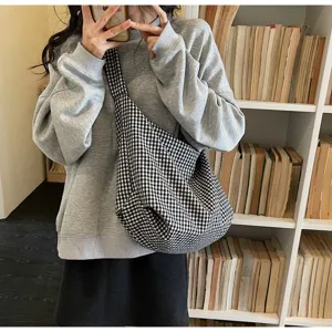 Detailed view of casual black and white checkered gingham canvas crossbody bag for women.