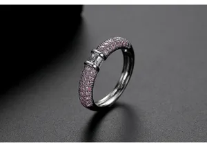 Detalle macro de un elegante anillo de latón plateado con circonitas rosas.
