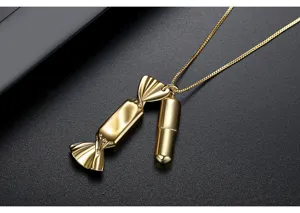 Close-up of a gold-plated necklace featuring creative candy and capsule charms