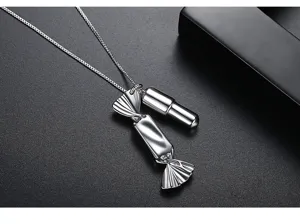 Close-up of silver-tone candy and capsule pendant necklace with polished finish.