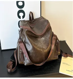 Dettaglio dello zaino marrone in ecopelle che mostra la trama e le tasche laterali.