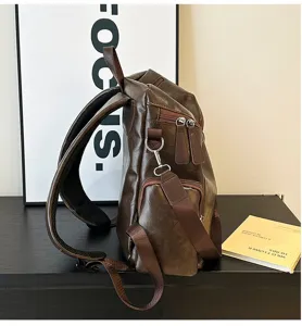 Vista laterale di zaino in pelle vintage marrone con spallacci regolabili e finiture metalliche