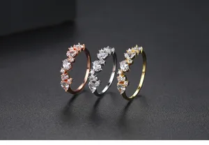 Primer plano de tres elegantes anillos en oro rosa, plata y oro con circonitas brillantes.