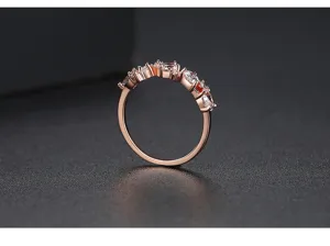 Vista lateral detallada de un elegante anillo chapado en oro rosa con circonitas cúbicas.