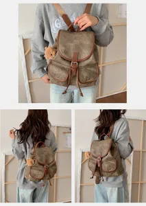 Close-up detail of vintage suede backpack with leather trim, buckle, and cute bear pendant charm.