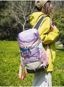 Λεπτομερής άποψη ενός ελαφρού πολύχρωμου σακιδίου πεζοπορίας που φοράει μια γυναίκα