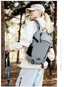 Vista detallada de una mochila de senderismo gris ligera con patrón de rejilla llevada por un modelo