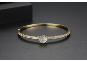 Détail du bracelet en laiton doré avec deux rangées de zircons cubiques micro-pavés.