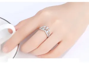 Detail view of a silver-toned crown-shaped ring with marquise zircons on a finger.