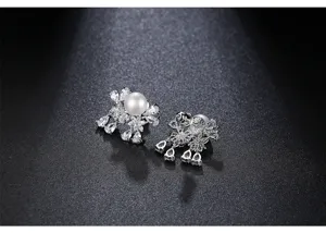 Close-up of elegant freshwater pearl stud earrings with sparkling cubic zirconia inlay.