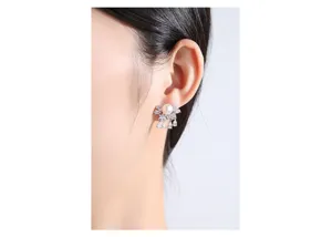 Elegant close-up of freshwater pearl stud earrings with sparkling zircon teardrops on ear
