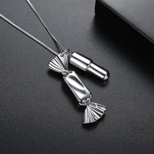 Unique silver-tone candy and capsule pendant necklace on a dark textured background