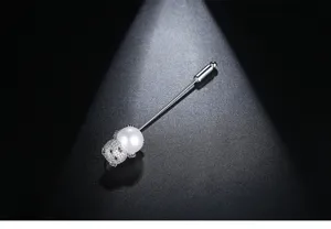 Nahaufnahme einer silbernen Bärenbrosche mit Zirkonia und einer weißen Perle.