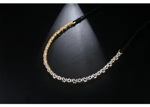 Detail view of a black ribbon choker with sparkling baguette-cut zircons and gold plating.