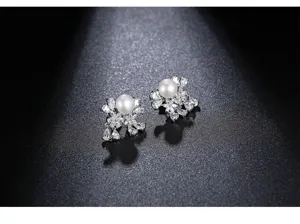 Close-up of elegant freshwater pearl stud earrings with sparkling floral zirconia