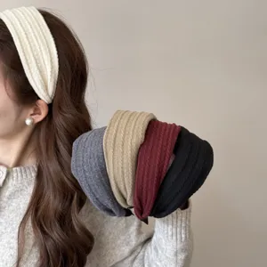 Vue détaillée de serre-têtes en maille torsadée aux couleurs d'automne portés par un modèle