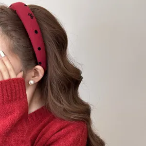 Detailed side view of a wide red polka dot headband showing the high cranium fit