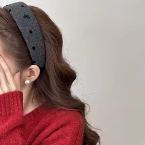 Gros plan d'un serre-tête en peluche gris à pois noirs porté par un mannequin asiatique